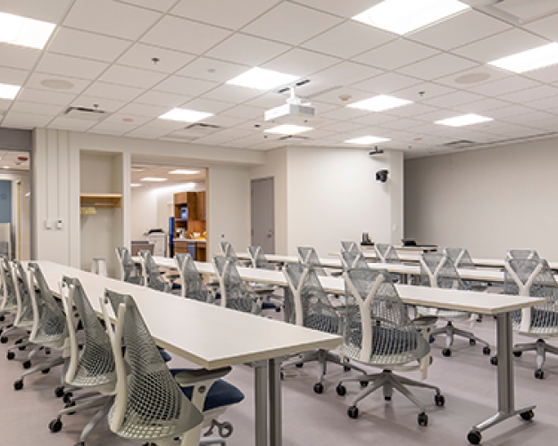 Image of 291 seminar room in Clark Hall with white chairs facing presenter podium