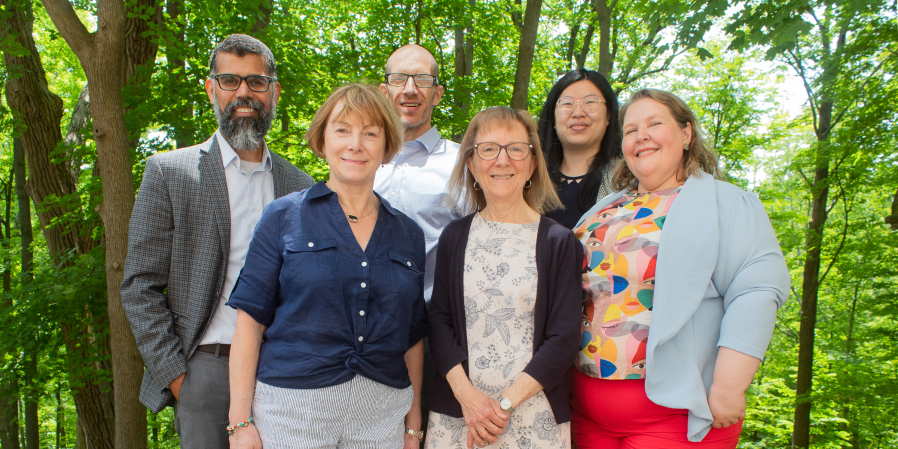 Image of Cassian D'Cunha, Lynn Martin, Peter Enns, Elena Goloborodko and two staff from McMaster University standing with trees in the background